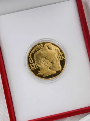 Zlatni zlatnik sa likom Miloša Obilića, slavnog srpskog junaka iz Kosovske bitke. Elegantno smešten u crvenu kutiju sa belom postavom. Simbol junaštva, vere i srpskog nasleđa.