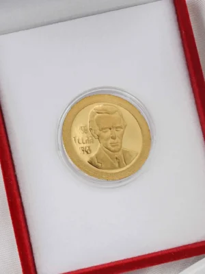 Zlatni zlatnik sa portretom Nikole Tesle i ugraviranim godinama rođenja i smrti (1856–1943). Smešten u crvenu kutiju sa belom postavom. Idealno za kolekcionare, poštovaoce nauke i srpske kulturne istorije.